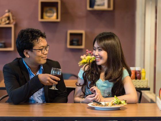 成熟夫妻在家中共享烛光晚餐，两人相视而笑，餐桌布置精心，氛围温馨浪漫，体现婚后亲密关系的用心经营