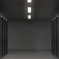 王思远，技术架构师，在服务器机房前检查系统运行状态，表情沉稳专业